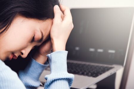 An asian woman getting anxiety and depression after checking news about global pandemic. Lockdown mental health. Coronavirus outbreakの写真素材