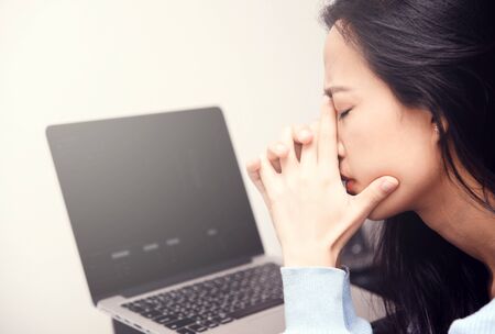 An asian woman getting anxiety and depression after checking news about global pandemic. Lockdown mental health. Coronavirus outbreakの写真素材