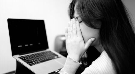 An asian woman getting anxiety and depression after checking news about global pandemic. Lockdown mental health. Coronavirus outbreakの写真素材