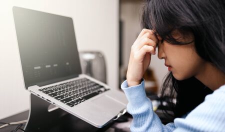 An asian woman getting anxiety and depression after checking stock market news about global...