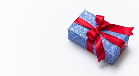 Blue gift box with red ribbons isolated on white background