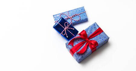 Blue gift box with red ribbons isolated on white backgroundの写真素材