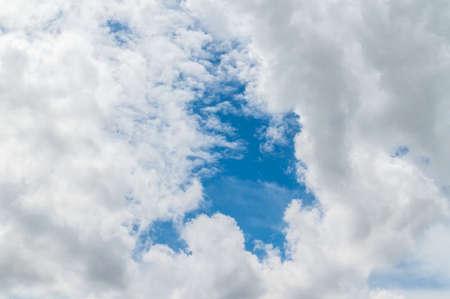 Storm clouds floating in a rainy day with natural light. Cloudscape scenery, overcast weather above blue sky. White and grey clouds scenic nature environment background.の写真素材