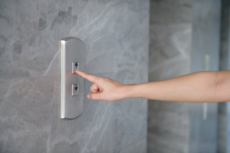 Cropped Hand Of Woman Pressing Push Button For Elevatorの写真素材