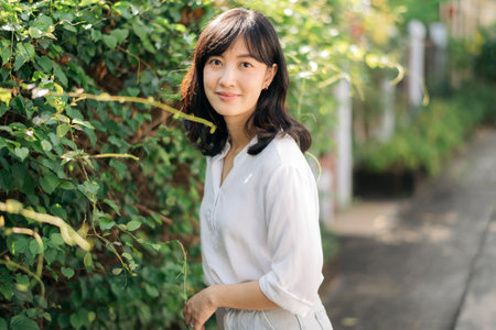 Portrait beautiful young asian woman happiness standing aside green plant wall, Happy female is...