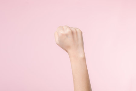Woman fist fight for human rights and feminist with pink pastel background. Women empowerment, strength, equality and courage conceptの写真素材