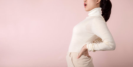 Young woman have back ache, waist pain, lumbar muscle injury problem. Office syndrome disease sick. Healthcare concept.の写真素材