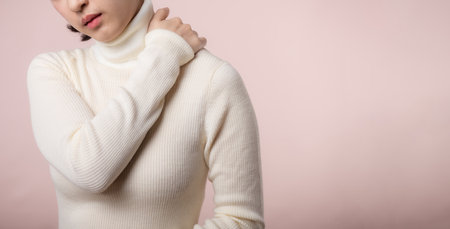 Young asian woman hold her hand on pain neck and injury ache shoulder stress problem muscle. Office syndrome disease, healthcare conceptの写真素材