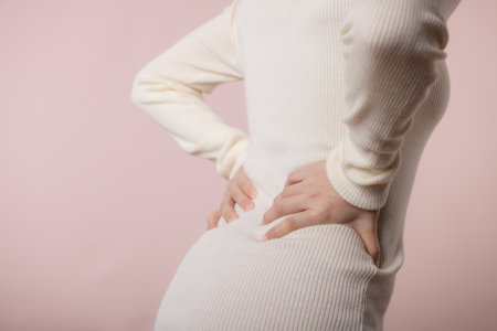 Young woman have back ache, waist pain, lumbar muscle injury problem. Office syndrome disease sick. Healthcare concept.の写真素材