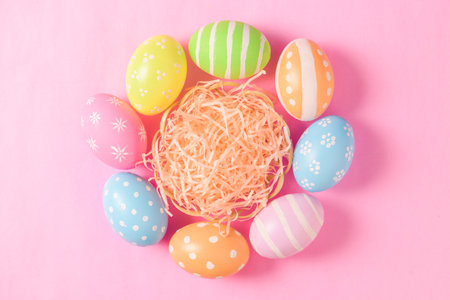 Happy Easter holiday greeting card concept. Colorful Easter Eggs pastel pink background. Top view,...