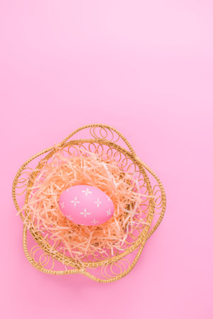 Happy Easter holiday greeting card concept. Colorful Easter Eggs pastel pink background. Top view, flat lay, copy space.の写真素材