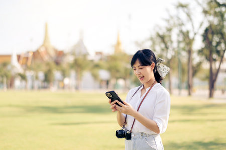 Portrait beautiful young asian woman with smartphone on summer holiday vacation trip in Thailandの写真素材