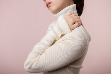 Young asian woman hold her hand on pain neck and injury ache shoulder stress problem muscle. Office syndrome disease, healthcare conceptの写真素材