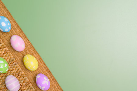 Happy Easter holiday greeting card concept. Colorful Easter Eggs and spring flowers on pastel green...