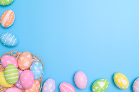 Happy Easter holiday greeting card concept. Colorful Easter Eggs and spring flowers on blue...