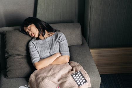 Asian woman with cold and flu sleeping on sofa bed.