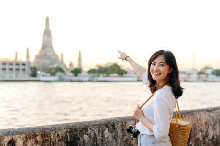 Portrait beautiful asian woman smiling while travel at Wat Arun sunset view point, Bangkok, Thailand.の写真素材