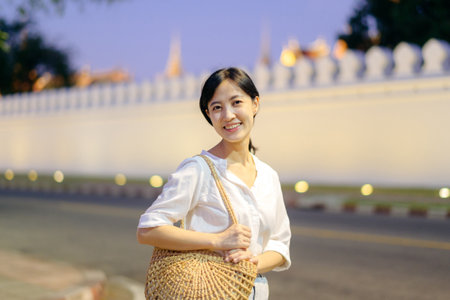 Portrait young beautiful asian woman smiling while travel at Golden palace in twilight view point, Bangkok.の写真素材