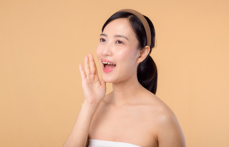 beauty young asian woman model with fresh glowing hydrated facial skin. girl person with natural makeup and healthy skin portrait isolated on beige studio background. spa treatment, skin care concept.の写真素材