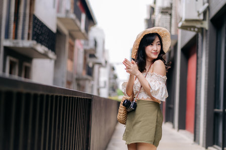 Happy asian youth woman with camera travels street city trip on leisure weekend. Young hipster female tourist sightseeing summer urban Bangkok destination. Asia summer tourism concept.の写真素材