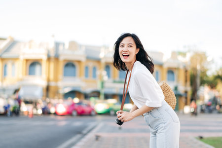 Portrait of young beautiful woman with camera explore street in Bangkok, Thailandの写真素材
