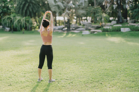 Female jogger. Back portrait of 30s asian woman wearing pink sportswear, breathing fresh air and...