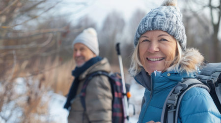 Portrait cheerful smiling middle age woman hiking walking with her husband enjoying free time and nature. Active beautiful seniors in love together at winter dayの素材