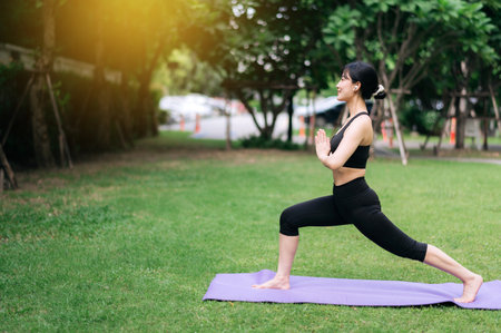 Embrace holistic well-being with outdoor yoga and fitness. A young asian woman wearing sportswear stretching muscle in park and finds balance, vitality, and serenity in nature's embrace.の写真素材