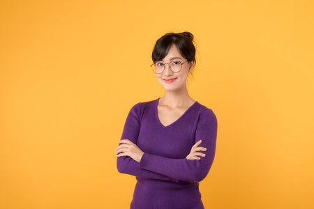 Portrait of young Asian woman on yellow background with copy space.の写真素材