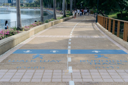 Explore the beauty of an urban oasis with a modern green path, perfect for relaxing stroll, all while dressed in an orange shirt.の写真素材