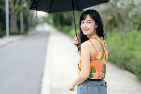 Embrace the sun safely. a portrait of an Asian woman with a bright, sun blocking umbrella.の写真素材