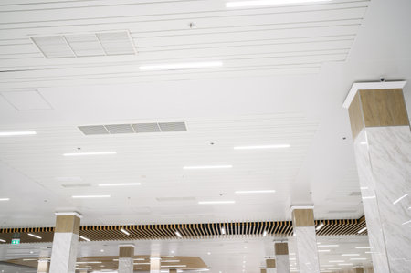Ceiling mounted cassette type air conditioner and modern lamp light on white ceiling. duct air...