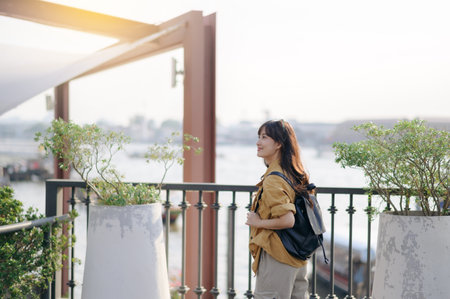 Young Asian woman backpack traveler in express boat pier on Chao Phraya River in Bangkok. Journey...