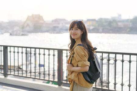 young Asian woman in her 30s embarking on a solo adventure. Backpack on, camera ready, she captures...