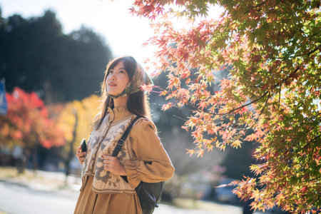 Kyoto's fall joy, Asian woman in casual dress explores nature's beauty, capturing the vibrant...