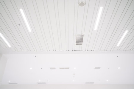 Ceiling mounted cassette type air conditioner and modern lamp light on white ceiling. duct air conditioner for office or homeの写真素材
