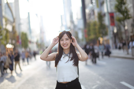 Experience the joy of city life through the eyes of vibrant Asian woman, a perfect mix of style, confidence, and happiness.の写真素材