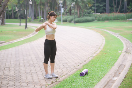 Shoulder pain problem. woman jogger. 30s asian female wearing white sportswear holding her shoulder...