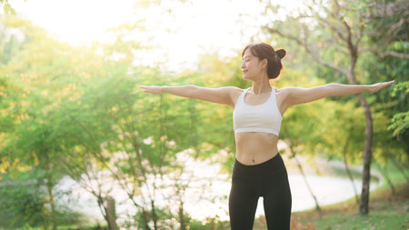Female jogger. Fit young Asian woman with sportswear stretching muscle in park before running and enjoying a healthy outdoor. Fitness runner girl in public park. Wellness being conceptの写真素材