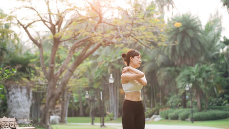 Shoulder pain problem. woman jogger. 30s asian female wearing white sportswear holding her shoulder...