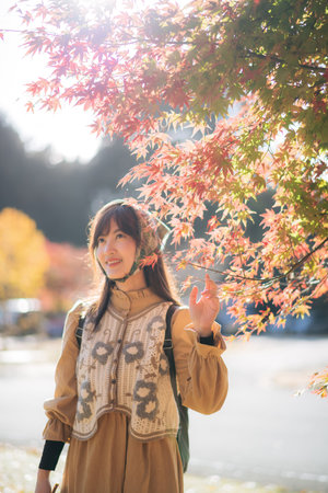Kyoto's fall beauty, Asian woman in casual dress enjoys a holiday, capturing the vibrant foliage, cheerful smiles, and the beauty of Kyoto's scenic destinations.の写真素材