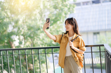 Traveler young asian woman 30s snaps a selfie with locals in Bangkok. Discover the beauty of cultural connection and shared experiences.の写真素材