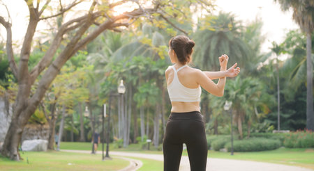 Female sportswoman. Fit young Asian woman with sportswear stretching muscle in park before running and enjoying healthy outdoor. Fitness runner girl in public park. Wellness being conceptの写真素材