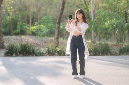Southeast asian female young woman enjoying refreshing deep breath in public park showing wellness...