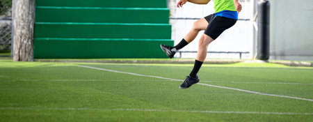 A soccer players in action on green grass field focusing on their legs and ball during intense game...