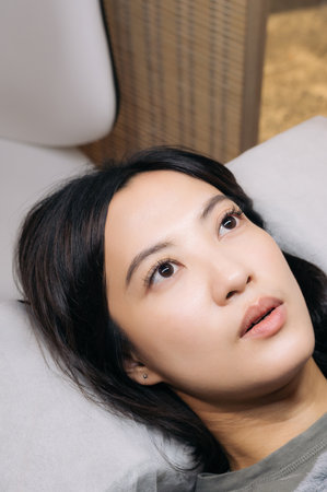 A young female southeast asian woman beauty salon receives an eyelashes extension procedure for...