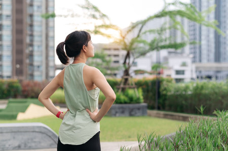 Asian woman 30s with healthy lifestyle. Fitness yoga workout and stretching exercise reduces medical injury risk shoulder pain muscle strain and inflammation. Urban city sunset wellnessの写真素材