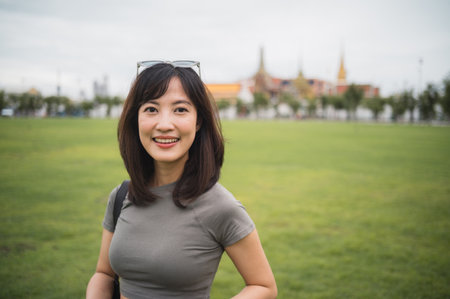 A happy solo southeast asian woman blogger enjoying world travel tourism experience. local cultural concept for an explorer in bangkok thailand, asiaの写真素材