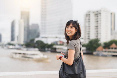A happy solo southeast asian woman teenager blogger and explorer world travel. an asia tourism concept to express local cultural experience, no wait for boat chao phraya river bangkok, thailandの写真素材
