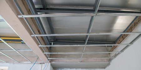 An interior renovation showing electrical wiring and aluminium ceiling framework. installation is part of major remodeling project leaving raw industrial feeling of being under constructionの写真素材